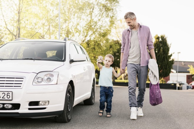 Far og sønn går ved bilen sin